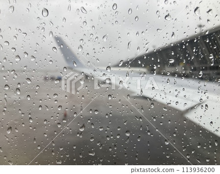 Wing and airport seen from an airplane window with drops Wing and airport seen from an airplane window with drops 113936200