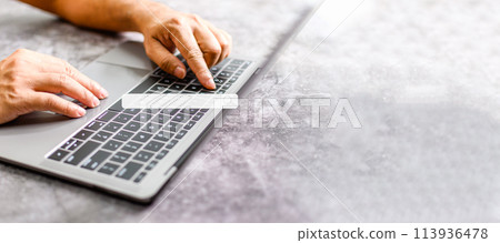 A man's hand rests on a laptop to use for job searching over the Internet. The concept for working from home, touch, website, networking, typing. Copy space on right for design. Blurred background A man's hand rests on a laptop to use for job searching over the Internet. The concept for working from home, touch, website, networking, typing. Copy space on right for design. Blurred background 113936478