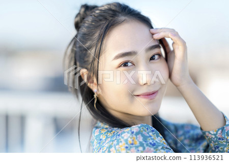 A young woman smiling looking at the camera 113936521