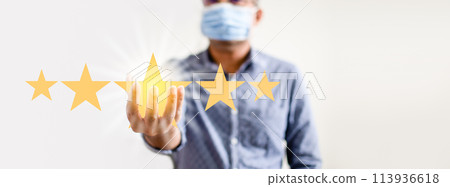 A man is holding up five stars, with one of them being a yellow star 113936618