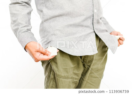 A man is standing with his hands in his pockets and looking down 113936739