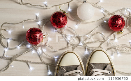 A pair of shoes are standing on a white surface with a string of lights and red A pair of shoes are standing on a white surface with a string of lights and red 113936760