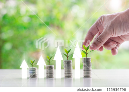 A hand is placing coins on top of a stack of coins 113936796