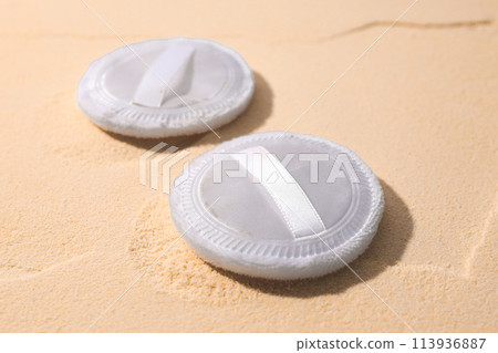A bottle of light-colored powder on a yellow background. 113936887