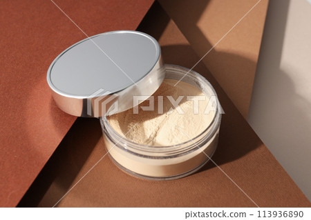 A bottle of powder, light shade, on a beige background. A bottle of powder, light shade, on a beige background. 113936890
