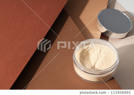 A bottle of powder, light shade, on a beige background. 113936891