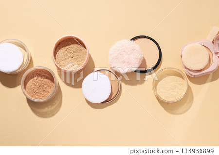 Bottles of face powder, different shades, on a pastel background. Bottles of face powder, different shades, on a pastel background. 113936899