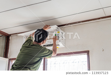 A man is fixing an air conditioner A man is fixing an air conditioner 113937123