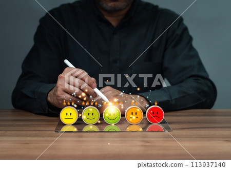 A man is drawing a smiley face on a table with five other faces 113937140