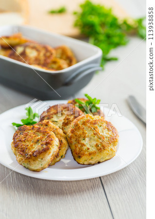 fried meat cutlets in a ceramic form on a wooden table 113938858