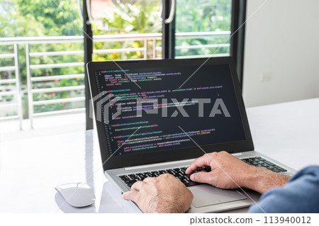 A man is typing on a laptop computer 113940012