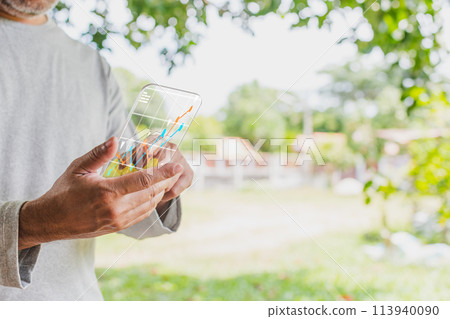 A man is holding a cell phone with a screen displaying a graph A man is holding a cell phone with a screen displaying a graph 113940090