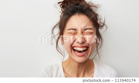 A woman with her eyes closed, exuding peace and tranquility as her hair is neatly styled in a bun. 113940174