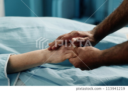 Unrecognizable male doctor holding hand of mature Caucasian woman before CT scan procedure in modern clinic Unrecognizable male doctor holding hand of mature Caucasian woman before CT scan procedure in modern clinic 113941219