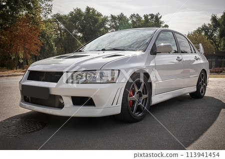 White car on a street background. Modern city sport car with spoiler wallpaper 113941454