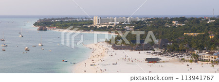 Panorama of Kendwa beach with a lot of people and a boat in the water 113941767