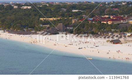 Kendwa beach with a lot of people and a boat in the water Kendwa beach with a lot of people and a boat in the water 113941768