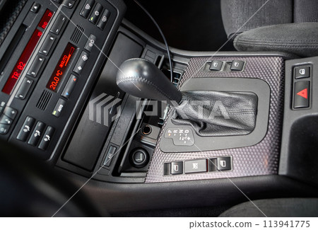Shift lever, car steering wheel and sensors. Inside a modern car view, city car interior background 113941775