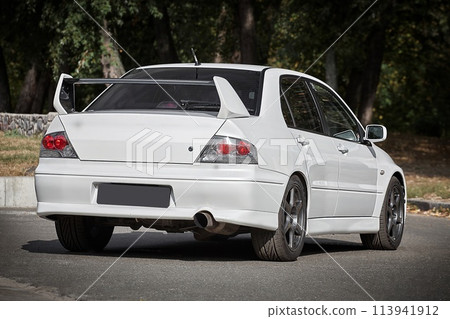 White car on a street background. Modern city sport car with a spoiler wallpaper White car on a street background. Modern city sport car with a spoiler wallpaper 113941912