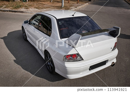 White car on a street background. Modern city sport car with a spoiler wallpaper 113941921