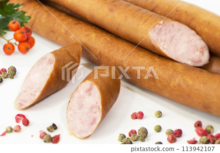 Tasty sausages and vegetables isolated over solid background Tasty sausages and vegetables isolated over solid background 113942107