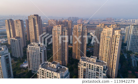 Aerial drone shot over residential apartment buildings on sunset. Aerial shot over community apartment complex in China. Aerial drone shot over residential apartment buildings on sunset. Aerial shot over community apartment complex in China. 113942279