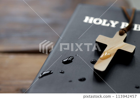 The holy Bible, the cross of Jesus, and the tears of sadness and gratitude of a Christian praying earnestly, religion and faith background 113942457