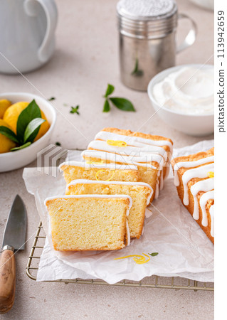 Classic lemon pound cake with powdered sugar glaze dripping over 113942659