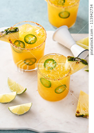 Pineapple jalapeno margarita cocktail in glasses with tajin rim Pineapple jalapeno margarita cocktail in glasses with tajin rim 113942734