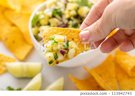 Fresh pineapple and jalapeno salsa in a bowl with tortilla chips Fresh pineapple and jalapeno salsa in a bowl with tortilla chips 113942743