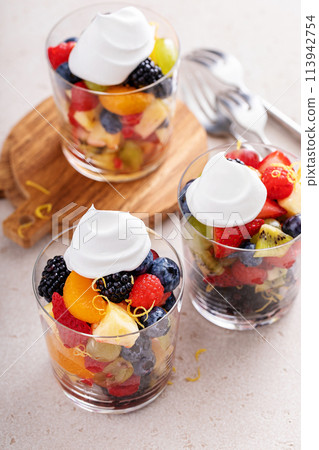 Fruit salad with berries and honey dressing served in a glass 113942754