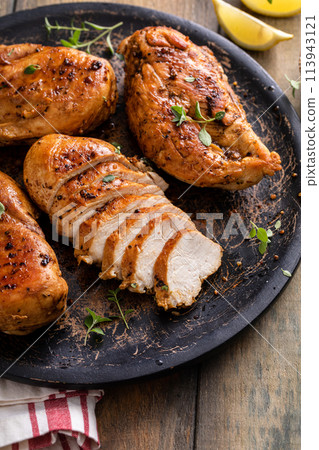Grilled or roasted chicken breast on a serving plate 113943121
