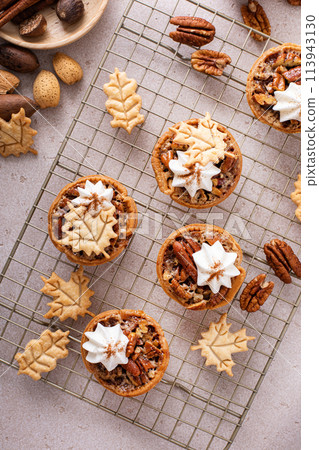 Mini pecan pies with whipped cream and fall leaves decoration 113943130