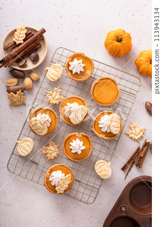 Mini pumpkin pies with pumpkin and fall leaves decoration Mini pumpkin pies with pumpkin and fall leaves decoration 113943134
