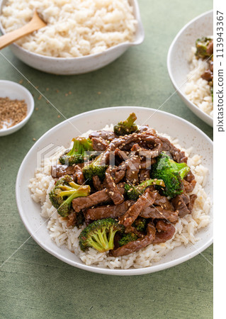 Beef and broccoli served over rice on a plate 113943367