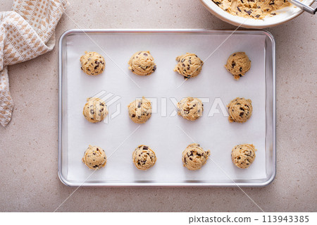 Chocolate chip cookie dough scoopes on a cookie sheet ready to be baked Chocolate chip cookie dough scoopes on a cookie sheet ready to be baked 113943385