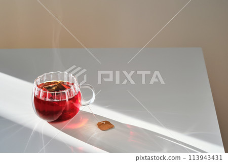 Glass mug with hot black tea on the table. Glass mug with hot black tea on the table. 113943431