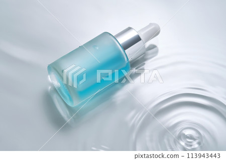 Bottles of cosmetics with a dropper in water on a blue background. 113943443