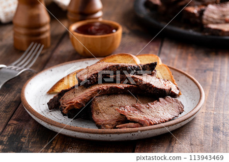 Sliced smoked brisket on a plate with toast 113943469
