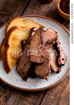 Sliced smoked brisket on a plate with toast 113943472