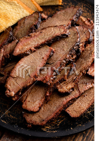 Sliced smoked brisket on a serving plate with toast 113943474