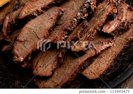 Sliced smoked brisket on a serving plate with toast Sliced smoked brisket on a serving plate with toast 113943475