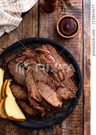 Sliced smoked brisket on a serving plate with toast 113943477