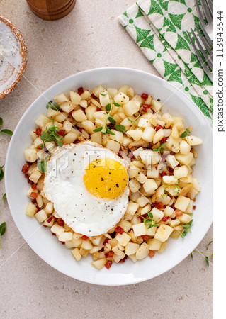 Potato hash with pancetta topped with a fried egg Potato hash with pancetta topped with a fried egg 113943544