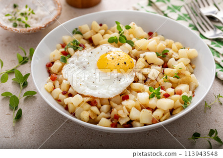 Potato hash with pancetta topped with a fried egg Potato hash with pancetta topped with a fried egg 113943548