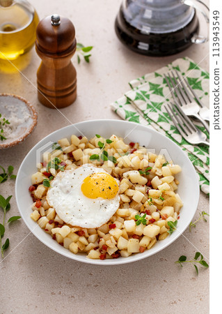 Potato hash with pancetta topped with a fried egg Potato hash with pancetta topped with a fried egg 113943549