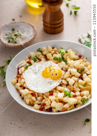 Potato hash with pancetta topped with a fried egg Potato hash with pancetta topped with a fried egg 113943550