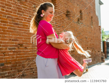 Mother holds and have fun her child with hearing aids and cochlear implants summer outdoor . Deaf and health concept. Diversity and Inclusion and people with disability concept. Copy space 113943760