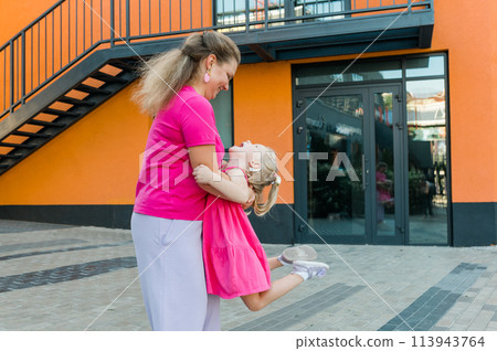 Mother holds and have fun her child with hearing aids and cochlear implants summer outdoor . Deaf and health concept. Diversity and Inclusion and people with disability concept. Copy space 113943764
