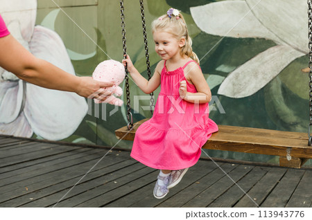 Funny baby with cochlear implant walks outdoor. Hearing aid and medicine innovating technology concept. Diversity and Inclusion and people with disability concept. 113943776